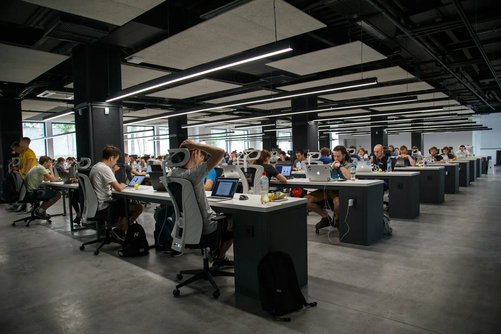 Großraumbüro mit vielen Entwicklern, die an Laptops arbeiten