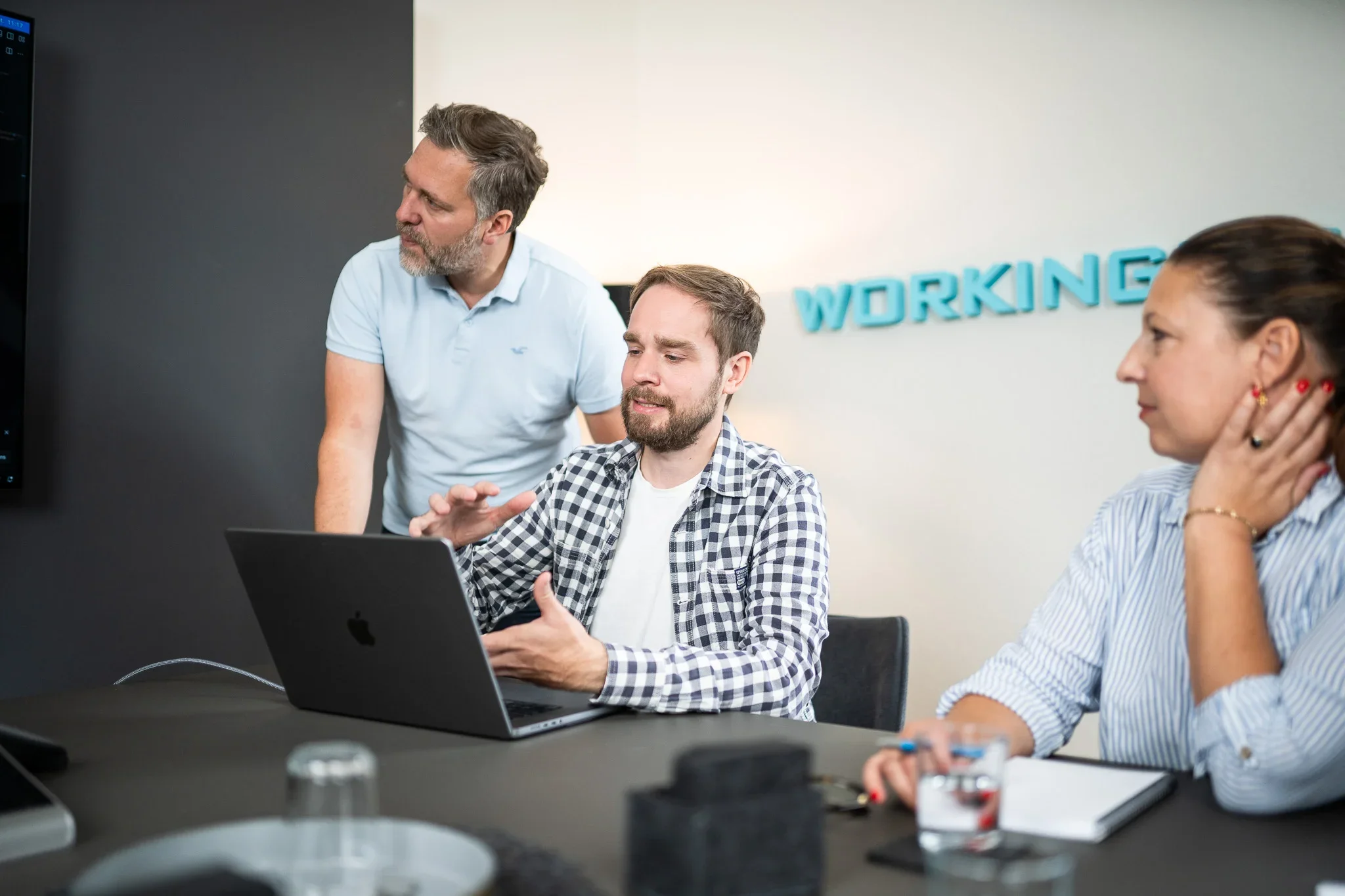 workingbits-Team bespricht gemeinsam am Laptop eine Prozesslösung